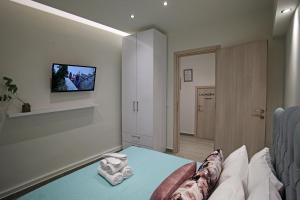 a bedroom with a bed and a tv on the wall at Under the Aqueduct boutique house in Kavála