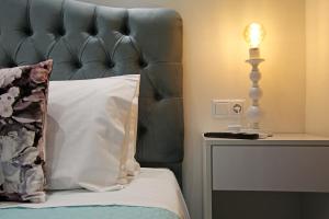 a bed with a black leather headboard and a lamp at Under the Aqueduct boutique house in Kavála