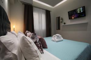 a bedroom with a bed with pillows and a tv at Under the Aqueduct boutique house in Kavála