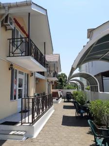 a building with a balcony and tables and chairs at Apartment Ureki in Ureki