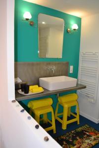 baño con lavabo y 2 taburetes amarillos en Chambre privative et originale, à 20 mn de Cluny, en Trivy