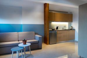 a living room with a couch and a table and a kitchen at Arion suites in Sarti