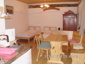 a kitchen and living room with a table and chairs at Petrovický mlýn in Kasanice