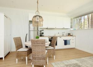 a white kitchen with a table and chairs at Sea View Studio Apartments by the Beach in Ihasalu