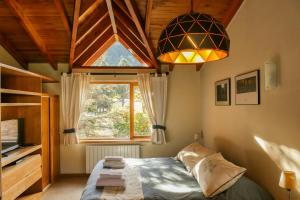 1 dormitorio con cama y ventana grande en Departamento Roca II - ubicacion perfecta en San Martín de los Andes