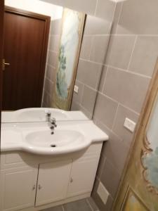 ein Badezimmer mit einem weißen Waschbecken und einem Spiegel in der Unterkunft bellaria in Voghera