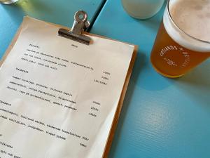 Tingstäde的住宿－Mejeriet Stenkyrka，一张桌子,上面有菜单和一杯啤酒