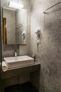 a bathroom with a sink and a mirror at Arion suites in Sarti