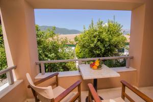 einen Balkon mit einem Tisch und Stühlen sowie Aussicht in der Unterkunft Orfeas Studios in Vasiliki