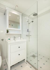 a white bathroom with a sink and a shower at Sea View Studio Apartments by the Beach in Ihasalu