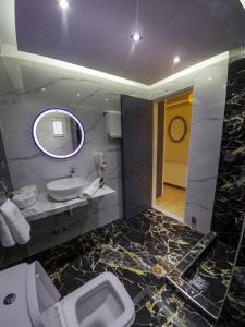 bagno con servizi igienici, lavandino e specchio di Family Inn Apartments&suites a Néos Marmarás