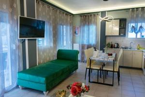 ネオス・マルマラスにあるFamily Inn Apartments&suitesのリビングルーム(緑のソファ、テーブル付)