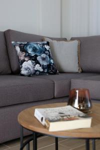 a living room with a couch with a book on a table at Under the Aqueduct boutique house in Kavála