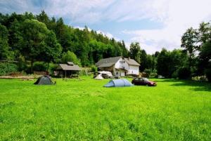 a group of tents in a field with a house at Petrovický mlýn in Kasanice