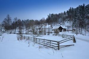 a fence in the snow in front of a house at Petrovický mlýn in Kasanice