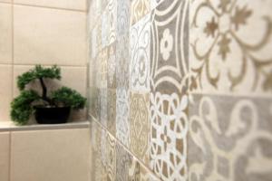 a bathroom with a tile wall with a potted plant at Under the Aqueduct boutique house in Kavála +80 photos