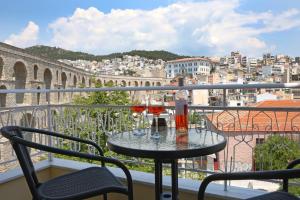 a table with two glasses of wine on a balcony at Under the Aqueduct boutique house in Kavála