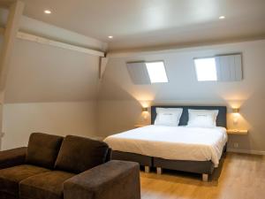 1 dormitorio con 1 cama, 1 sofá y 2 ventanas en Cosy family home with pool, en Moorslede