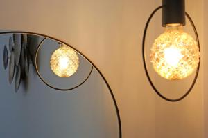 two lights and a mirror on a wall at Under the Aqueduct boutique house in Kavála