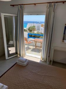 a bedroom with a bed and a view of the ocean at Pelagos Studios in Platis Yialos Mykonos