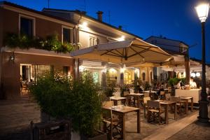 an outdoor restaurant with tables and umbrellas at night at Locanda Remare in Cesenatico