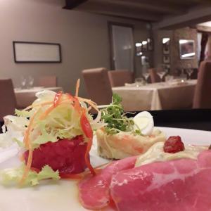 a plate of food with meat and salad on a table at Al biancospino- Camere- Ristorante in Bossolasco