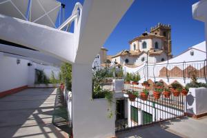 ein weißes Haus mit Topfpflanzen auf einem Zaun in der Unterkunft Casa Baños de la Villa in Priego de Córdoba