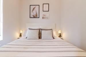 1 dormitorio con 1 cama blanca y 2 lámparas en Muy Luminoso a 5 min del centro de Bilbao, en Bilbao
