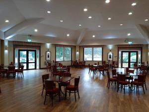 a restaurant with tables and chairs in a room at Fenna Lakeside Lodge - Pine Lake Resort in Carnforth