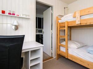 KolindにあるHoliday Home Kraghøjvejの二段ベッド1組、デスクが備わる小さな客室です。