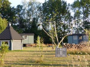 a small house in a field with a sign in the grass at les trois bergers in Serley