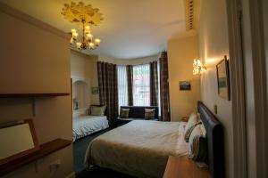 1 dormitorio con 1 cama y sala de estar en Dunallan Guest House en Perth