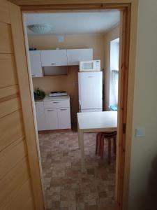 a small kitchen with a white refrigerator and a table at House of Possiet in Pärnu