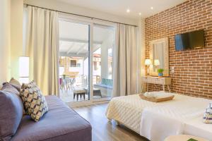 a living room with a bed and a brick wall at Golden Beachside terrace in Chrysi Ammoudia