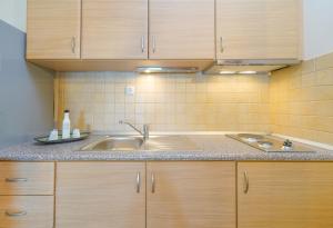 a kitchen with a sink and wooden cabinets at Golden Beachside terrace in Chrysi Ammoudia +32 photos