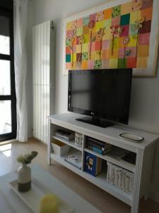 TV de pantalla plana en un centro de entretenimiento blanco en Patio, en Zamora