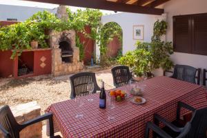 an outdoor table and chairs with a table and an outdoor oven at Can Moya in Sant Ferran de Ses Roques