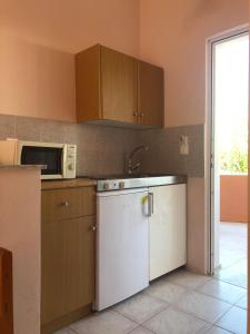 a kitchen with a white dishwasher and a microwave at Panagiotis Studios in Laganas