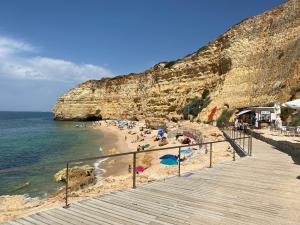 a beach with people on the sand and the ocean at Casa do Milho in Carvoeiro