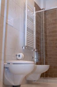 La salle de bains est pourvue de toilettes et d'une douche en verre. dans l'établissement Costa46, à Naples