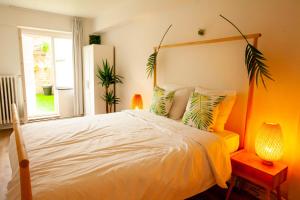 een slaapkamer met een groot wit bed en een raam bij Maison Rebelle in Oostende