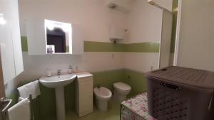 a green and white bathroom with a sink and a toilet at Nice Home Pizzo in Pizzo +34 photos