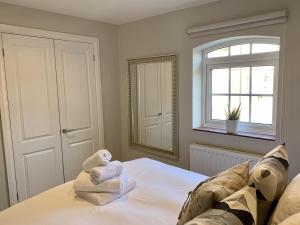 a bedroom with a bed with towels on it at Brewery Cottage in Abingdon