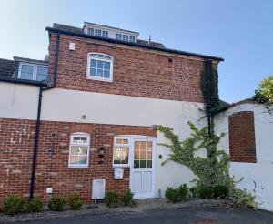 a red and white brick house with a white door at Brewery Cottage in Abingdon