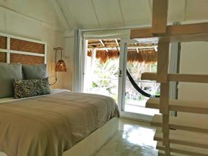 a bedroom with a bed and a large window at Coco Unlimited in Tulum +101 photos
