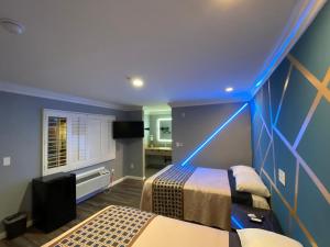 Habitación azul con 2 camas y TV en ERTH INN by AGA Maywood, en Maywood