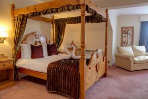 a bedroom with a canopy bed and a couch at Best Western Plus Bentley Hotel in Lincoln +65 photos