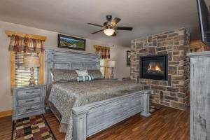 ein Schlafzimmer mit einem Bett und einem Kamin in der Unterkunft Heavenly Haven chalet in Gatlinburg