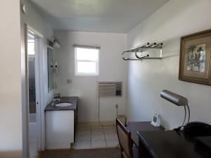 a small bathroom with a sink and a counter at Autumn's Inn in Roundup