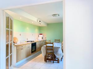 瓦里勒斯的住宿－Spacieuse maison dans un parc privée，厨房设有绿色的墙壁和桌椅